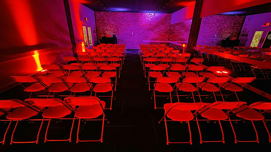 Seating and stage shown in the Halloween Open Mic listing.