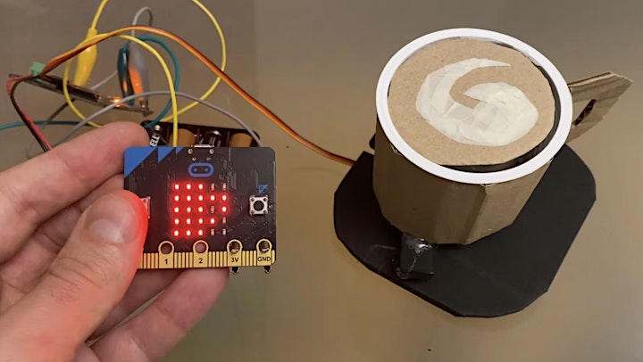 Microbit attached with wires to a cardboard coffee cup.