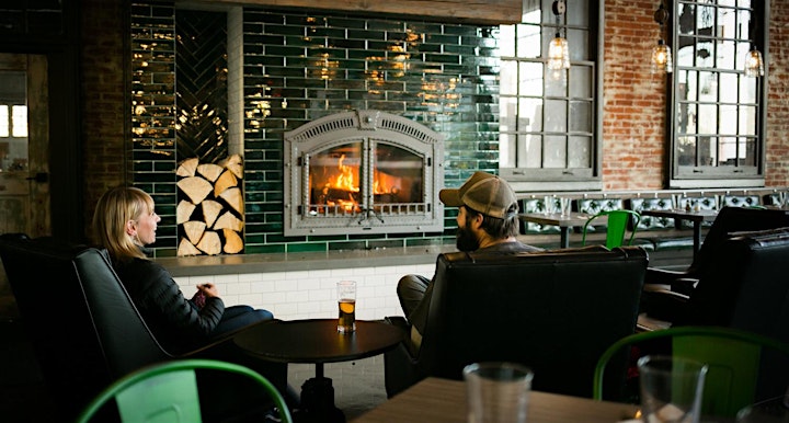Two people enjoy the fire at Last Chance Cider before a night of billings comedy.