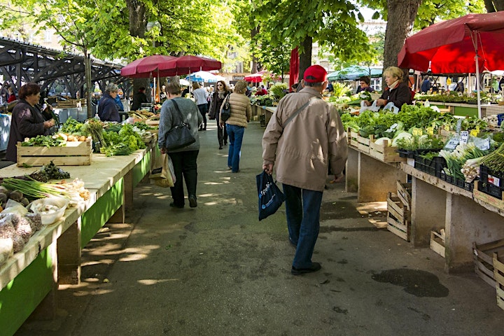 People shopping for groceries at an open street market. 