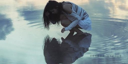 девушка смотрит на свое отражение в луже